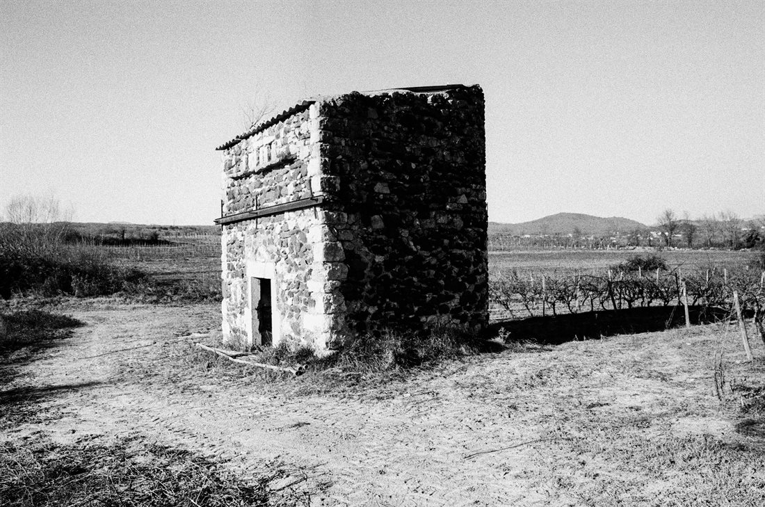 Ardèche, noir et blanc granuleux contrasté, cabanon de vignes en pierres à toit en tôle plat à une pente
